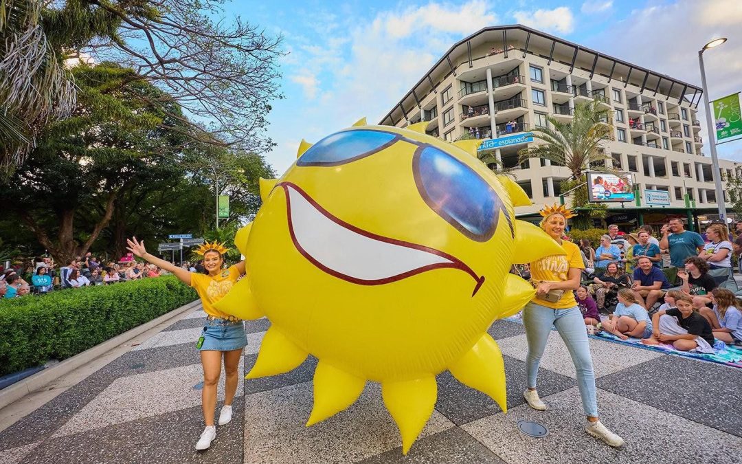 Performers carry a giant inflatable sun in the Cairns Festival Grand Parade on the Esplanade